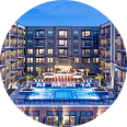 Modern apartment building with illuminated windows and outdoor pool
